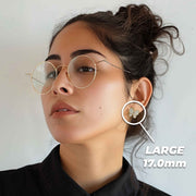 Close-up of a woman wearing large 17.0mm gold butterfly stud earrings with cubic zirconia.