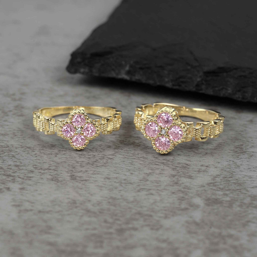 Two sizes of 10k gold luxe clover rollie band rings with pink cubic zirconia.