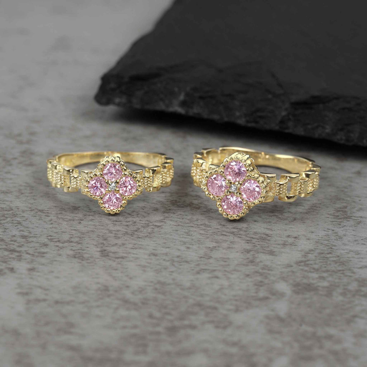 Two sizes of 10k gold luxe clover rollie band rings with pink cubic zirconia.