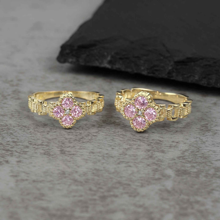 Two sizes of 10k gold luxe clover rollie band rings with pink cubic zirconia.
