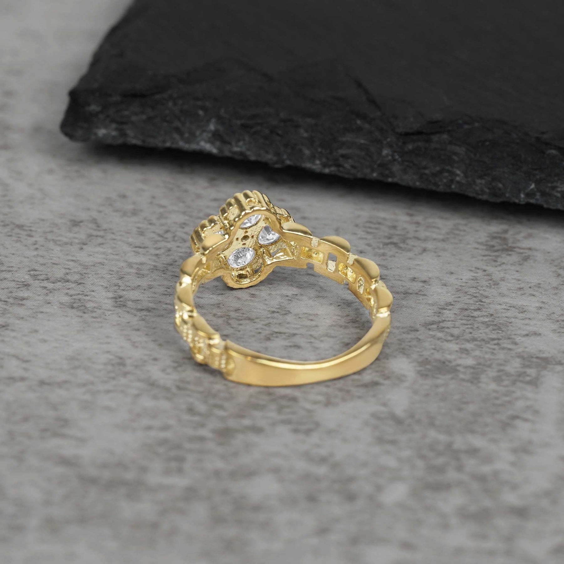 Underside view of a 10k gold Rolex-style ring showing white clover settings.