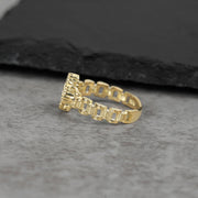 Side profile view of a 10k gold Rolex-style link band ring on stone.