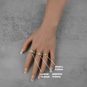 Hand wearing three gold clover rings labeled large, medium, and small sizes.