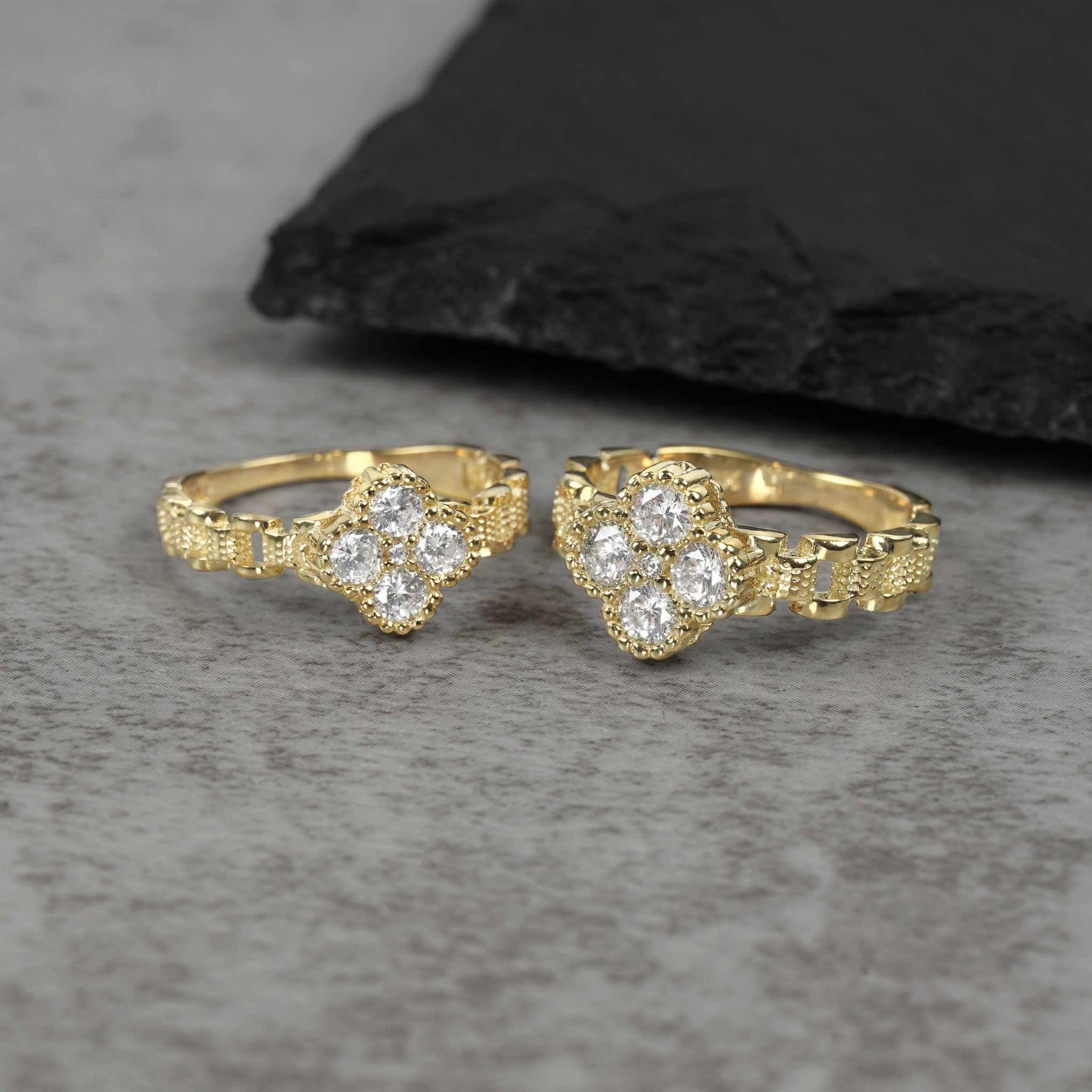 Small and large gold clover band rings with white cubic zirconia.