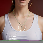 Woman wearing a white top and gold necklace with a small 21.0mm cross pendant.
