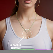 Woman wearing a white top and gold necklace highlighting an x-small cross pendant.