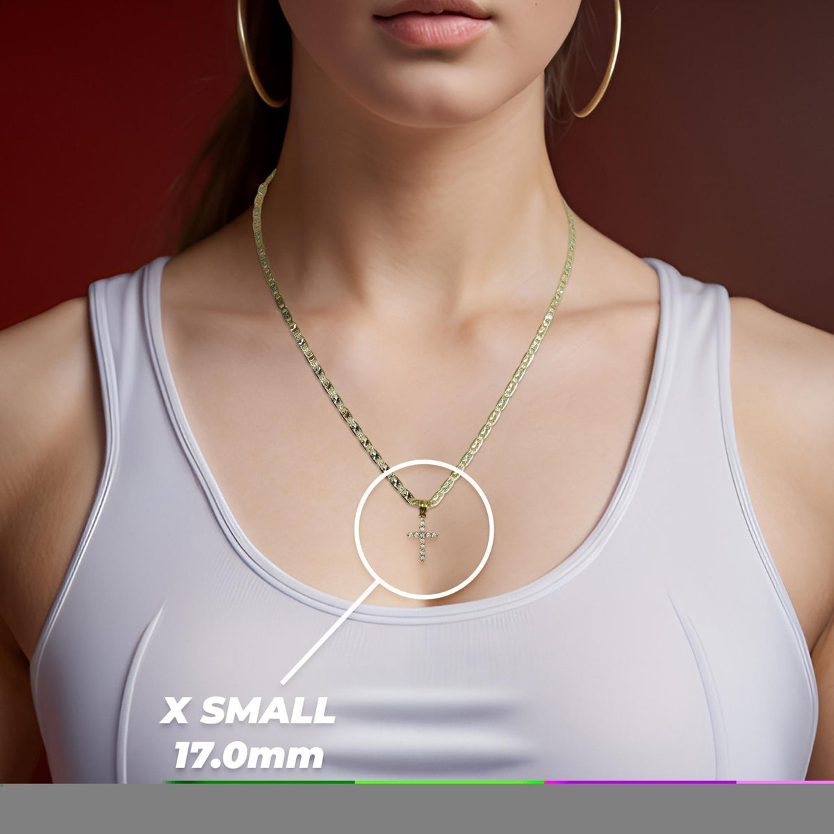 Woman wearing a white top and gold necklace highlighting an x-small cross pendant.