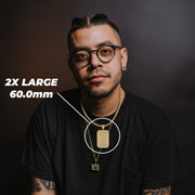 Man in glasses and black shirt showcasing the 60.0mm extra large gold pendant.
