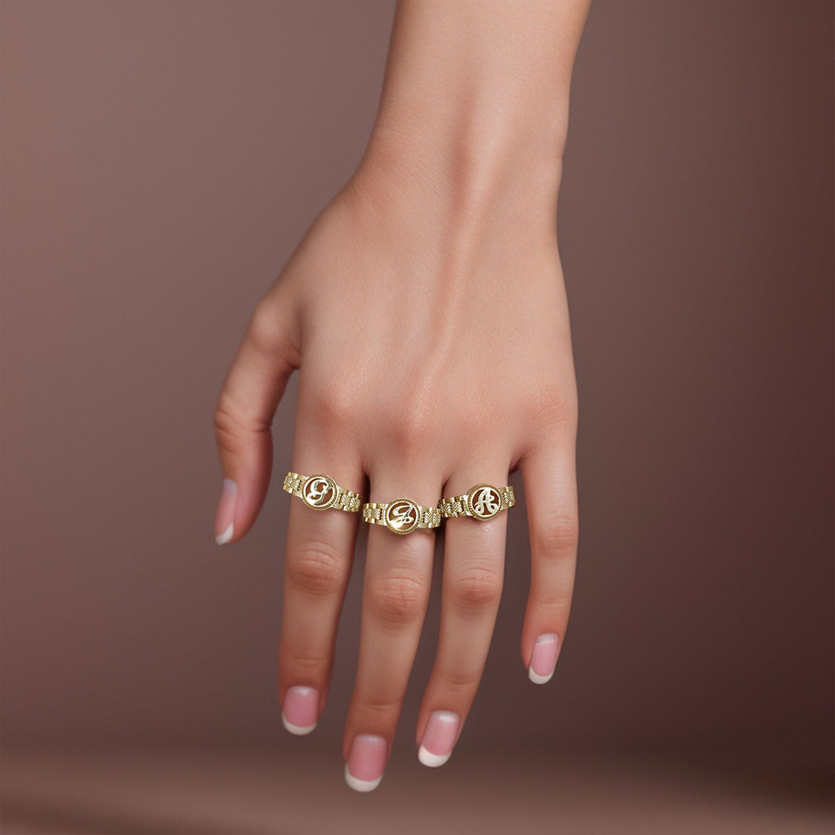 Lifestyle shot showcasing multiple script variations of the 10k gold round initial ring.