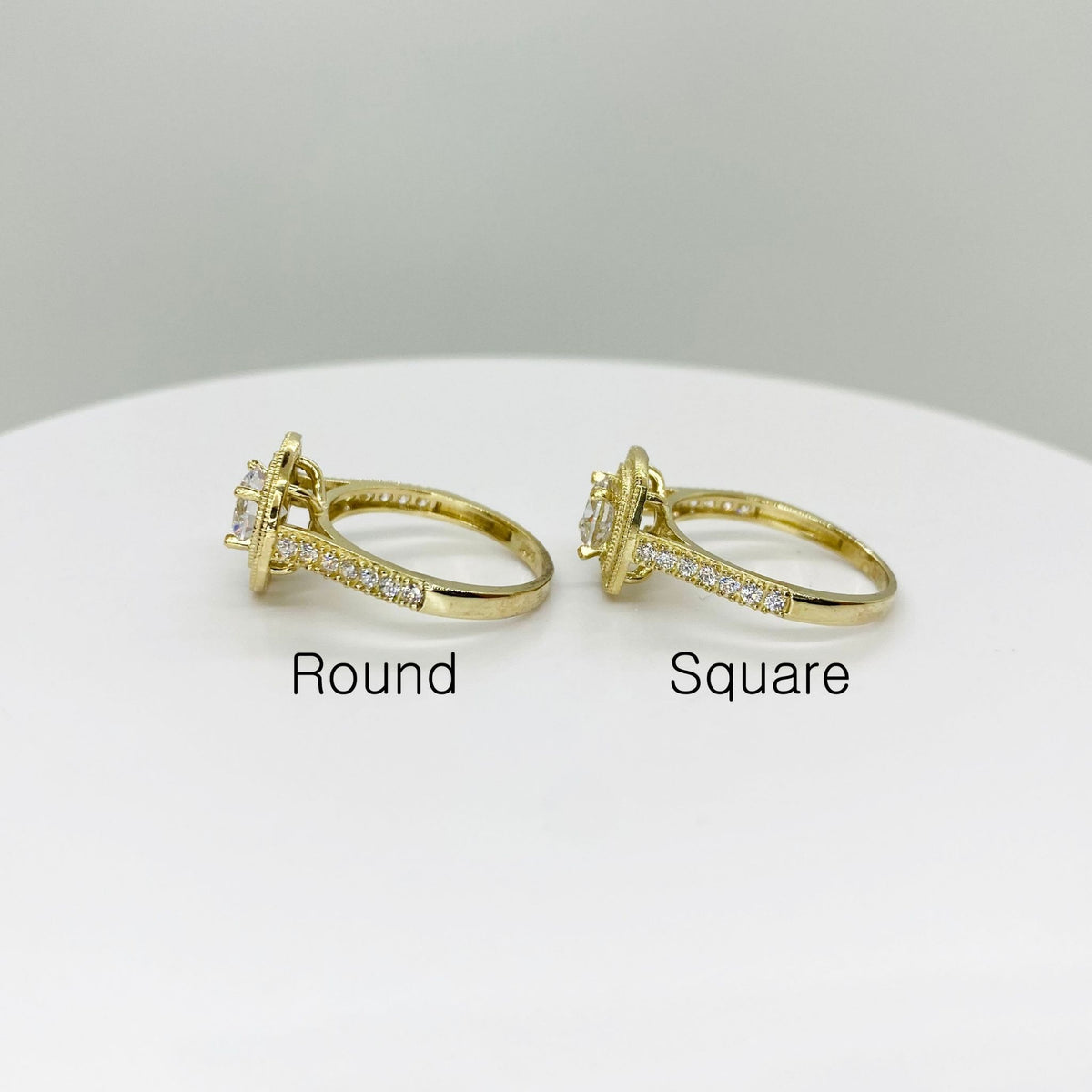 Two 10k gold rings with round and square stone shapes side view on a white background