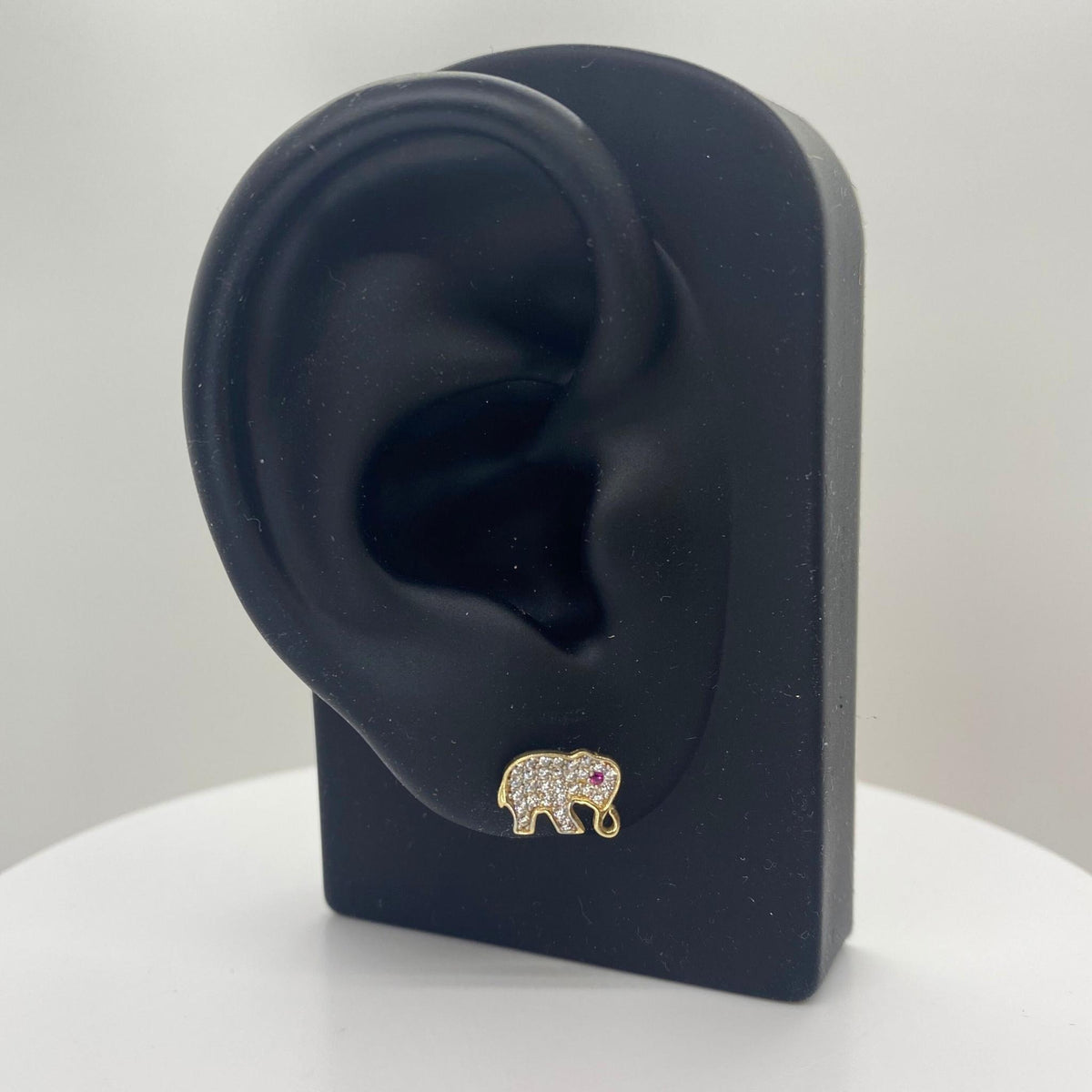 10k gold elephant stud earring with cubic zirconia on a black mannequin ear stand.