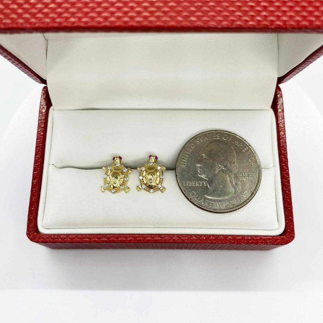 10k gold turtle stud earrings with cubic zirconia and a U.S. quarter for scale.