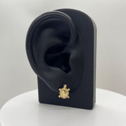 Small 10k gold turtle stud earring displayed on a black mannequin ear jewelry stand.