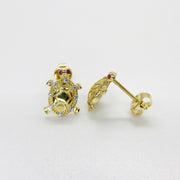 Pair of gold sea turtle stud earrings with sparkling cubic zirconia on white background.
