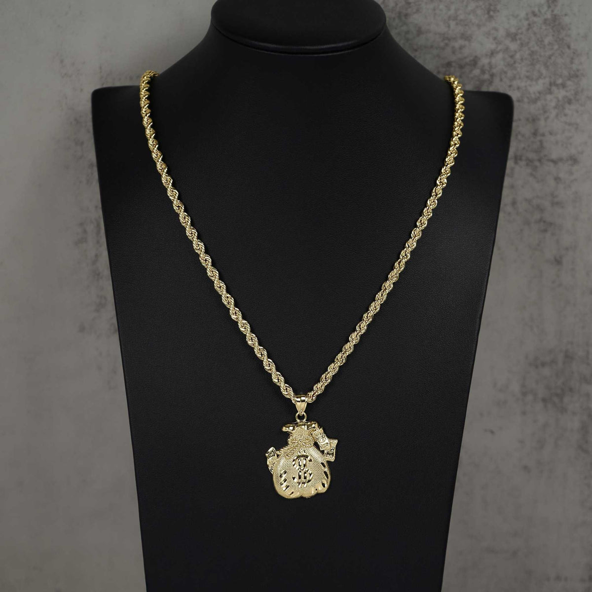 10k gold money loot bag pendant necklace on gold rope chain displayed on black mannequin.