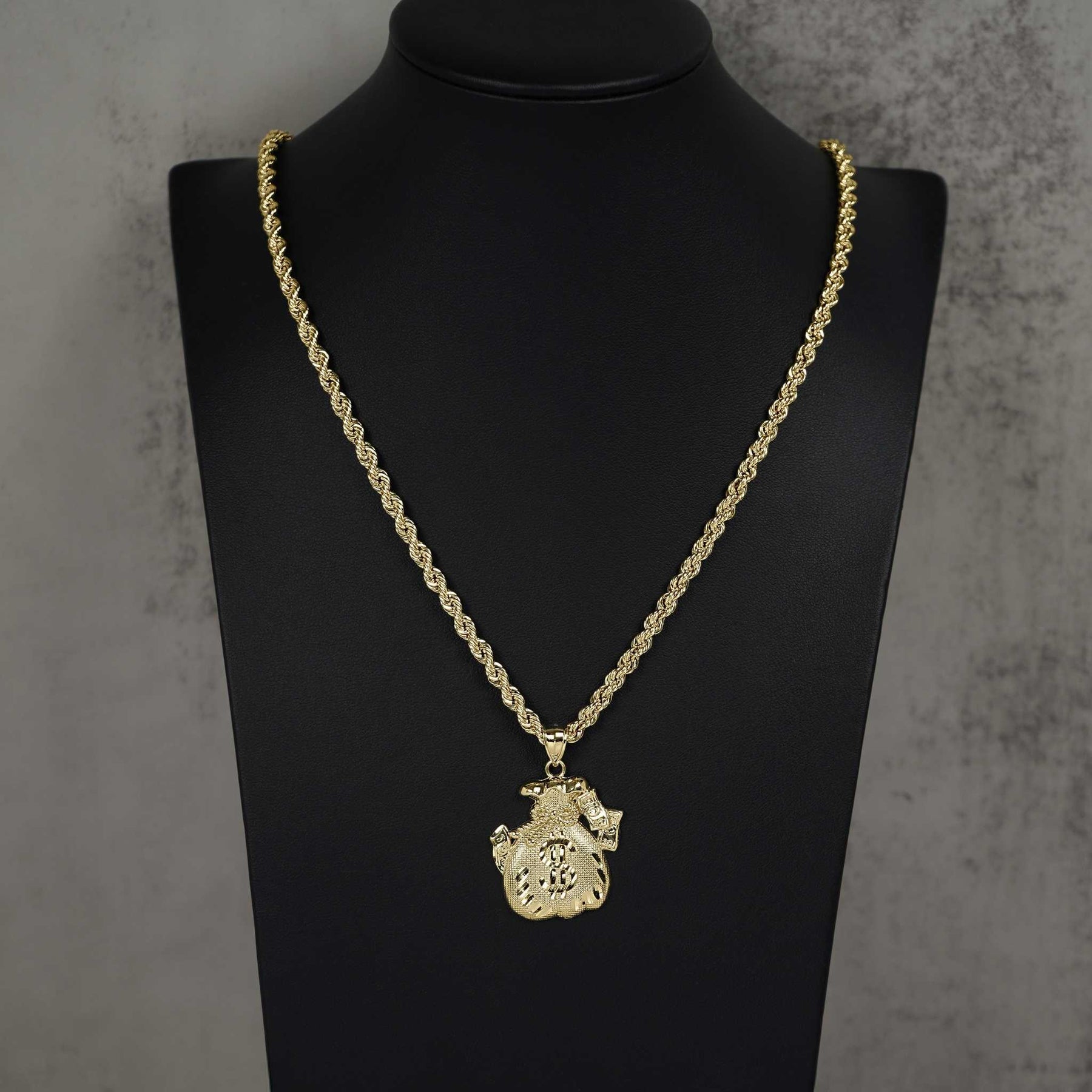 10k yellow gold money bag pendant necklace displayed on a black mannequin.
