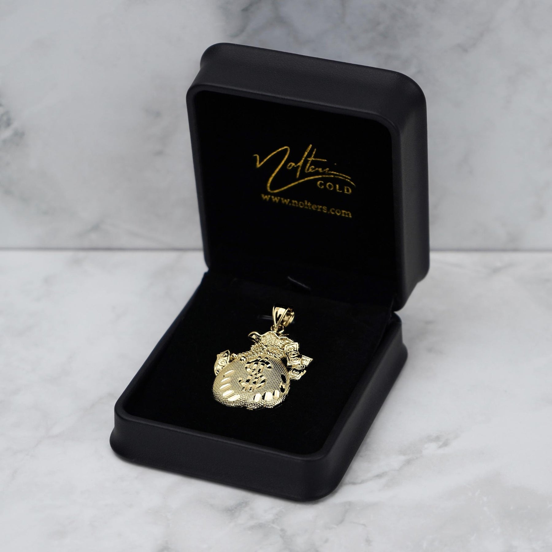10k yellow gold money bag pendant displayed inside an open black jewelry box.