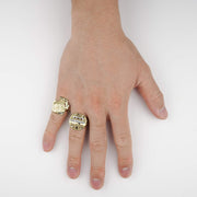 Hand wearing a 10k gold money loot bag ring and another statement ring.