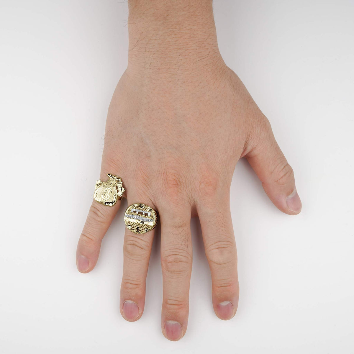 Hand wearing a 10k gold money loot bag ring and another statement ring.