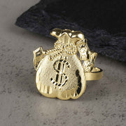 10k gold money loot bag signet ring with dollar sign on textured rock.