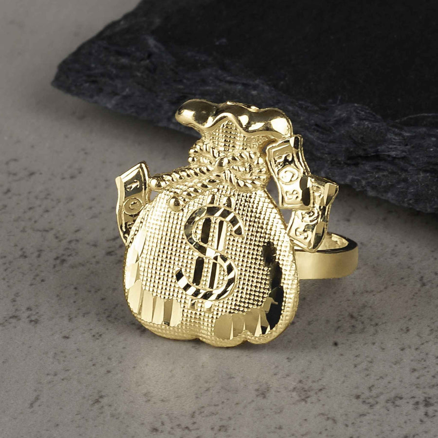 10k gold money loot bag signet ring with dollar sign on textured rock.