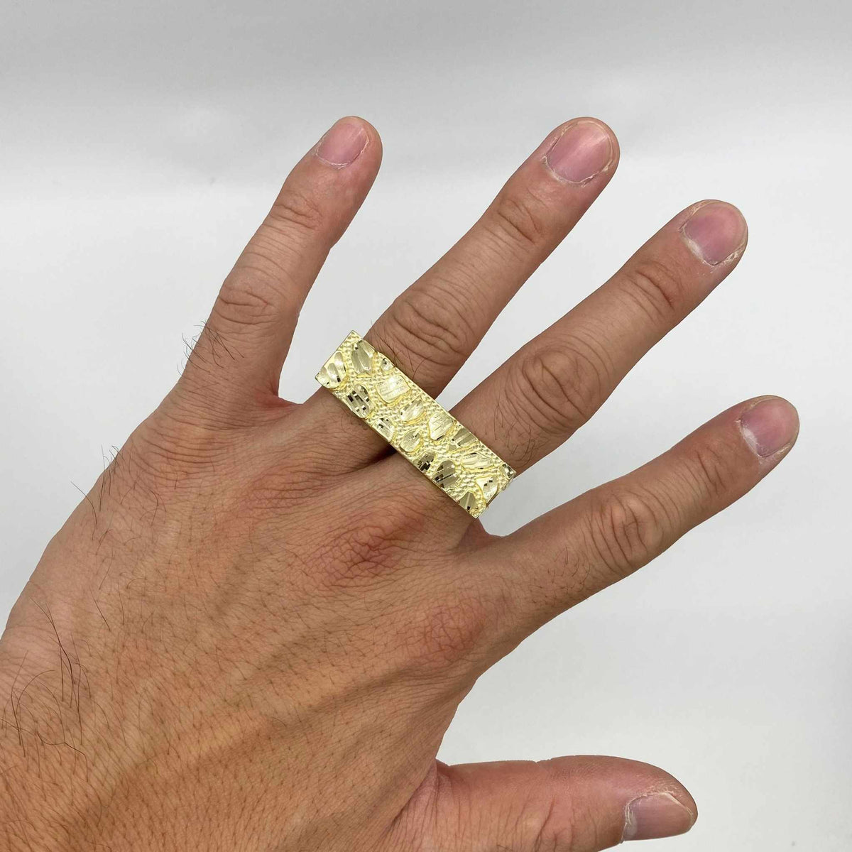10k Gold Nugget Classic Two Finger Ring on a person's finger against a white background
