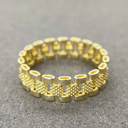 10k Gold Rollie Eternity Band ring on a gray surface