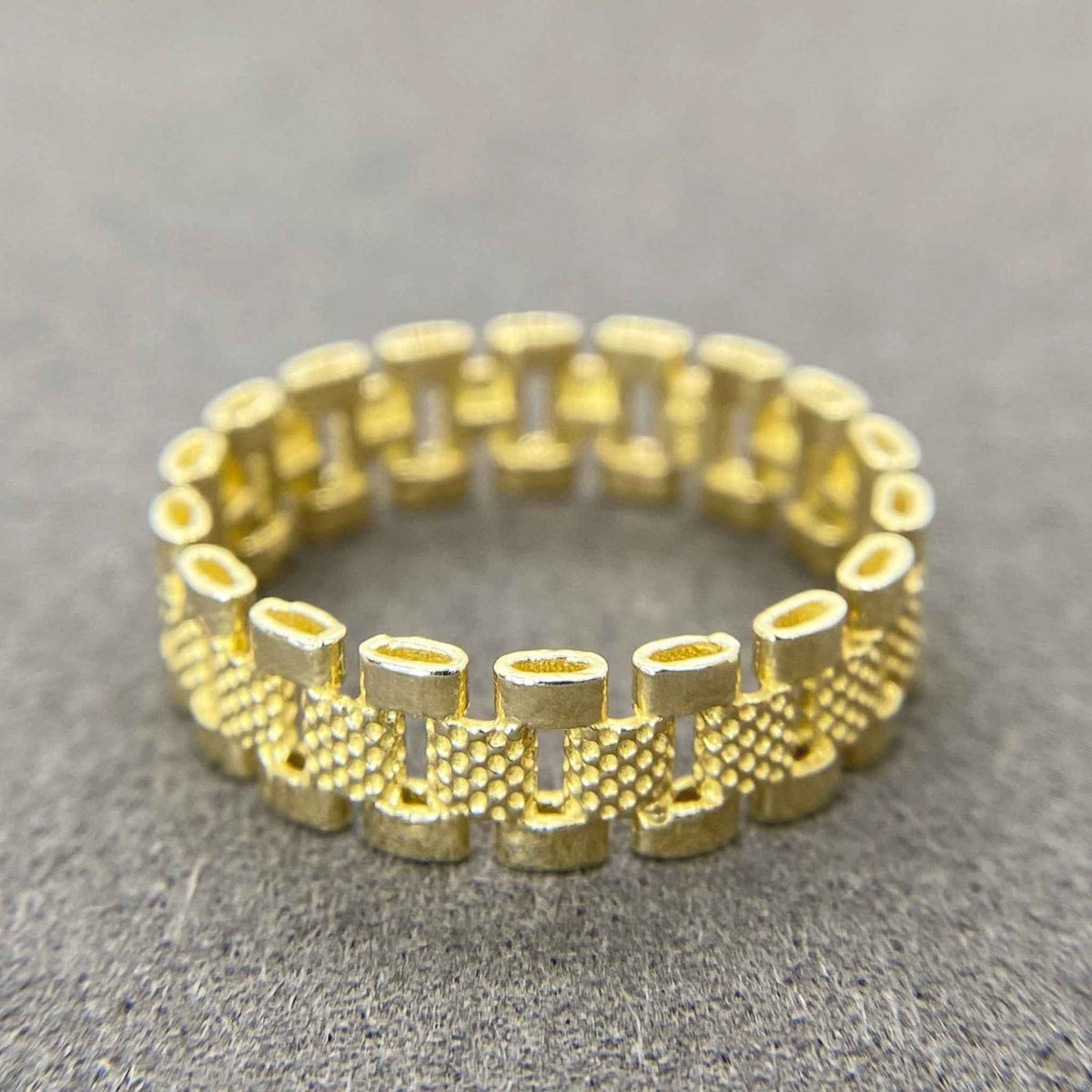 10k Gold Rollie Eternity Band ring on a gray surface
