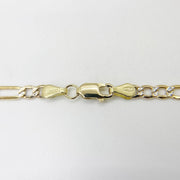 Close-up of 10k yellow gold Figaro chain showing lobster clasp on white background.