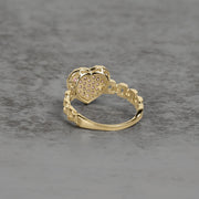 Back view of a gold heart-shaped ring showing the openwork textured setting.