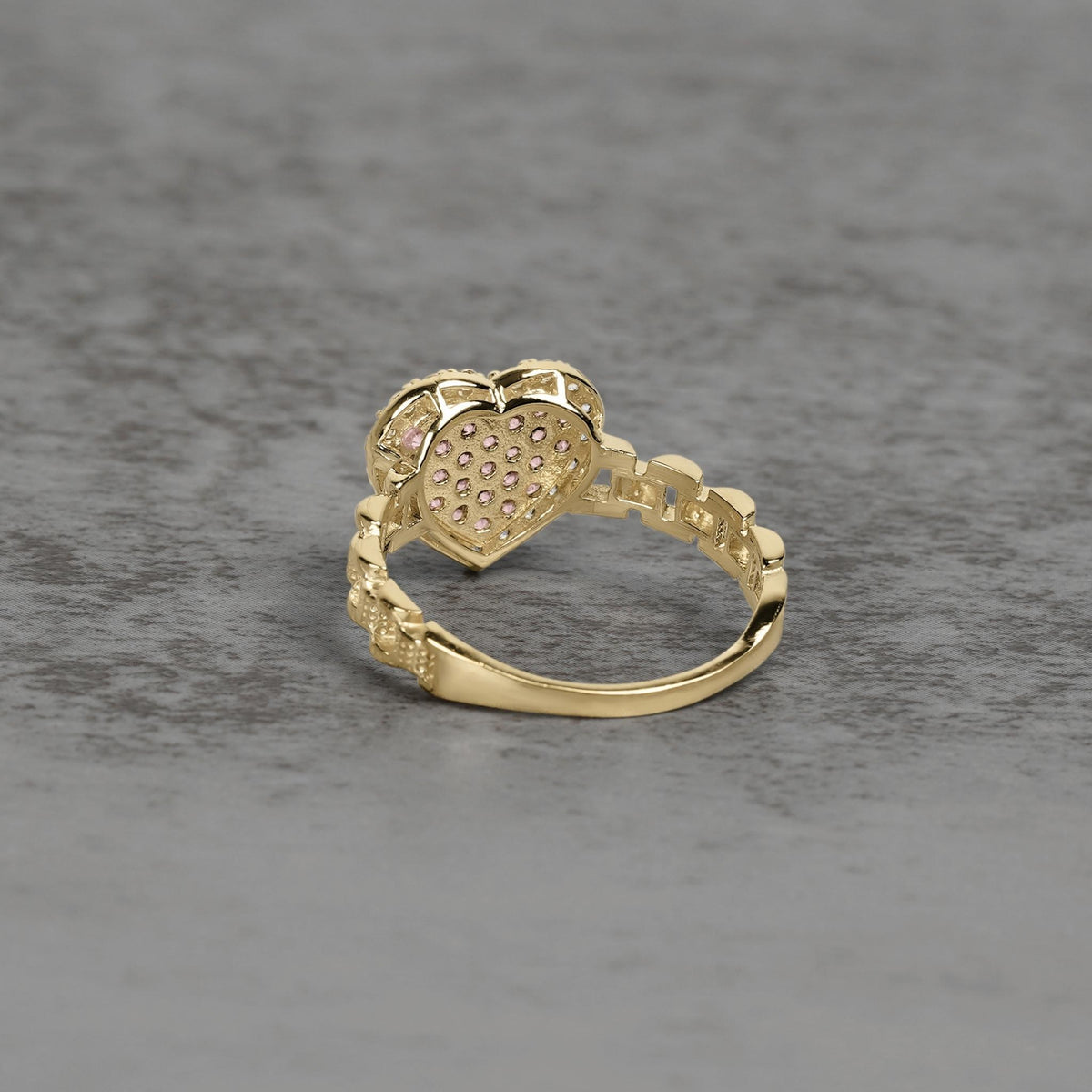 Back view of a gold heart-shaped ring showing the openwork textured setting.