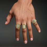 Model's hand wearing a 10k gold money tree ring alongside two other gold rings