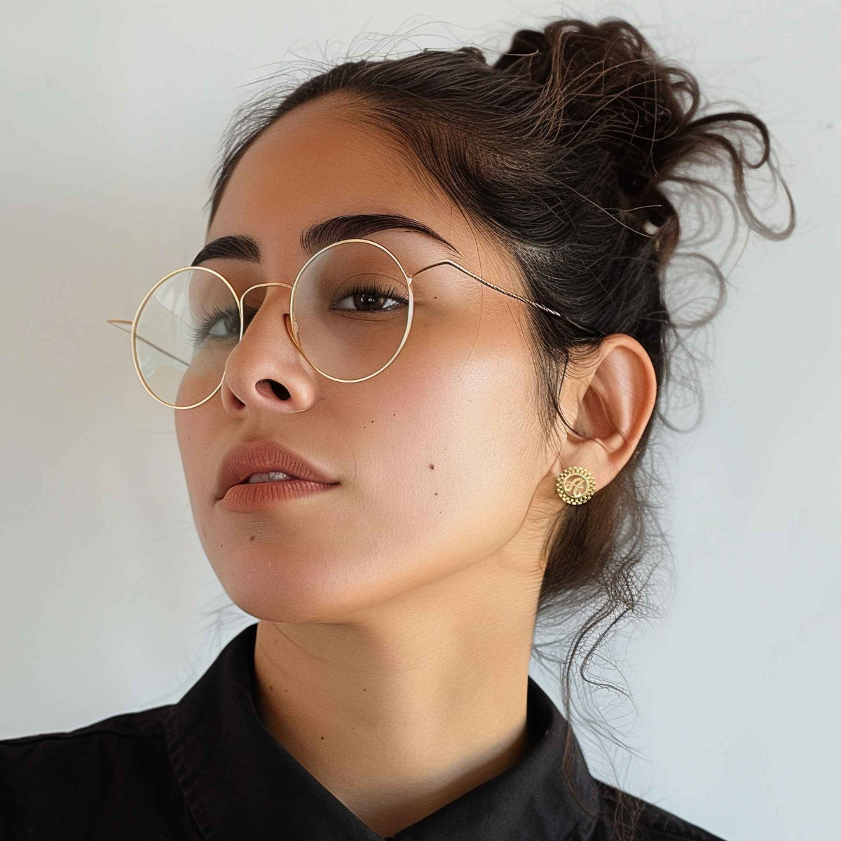 A woman wearing the 10k gold Rolli Rolex-style initial stud earring in her ear.