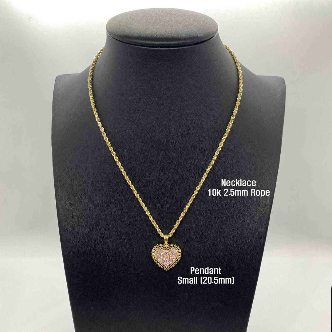 Open hand displaying small, medium, and large gold heart pendants with pink stones.