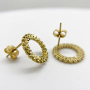 Pair of 10k yellow gold stud earrings featuring a textured, beaded, rollie-style circular design.