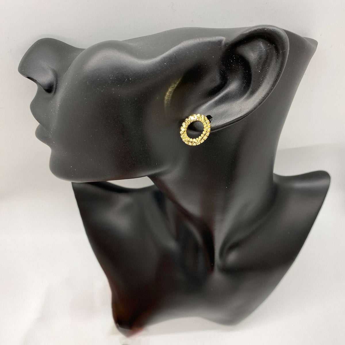 Textured 10k gold round stud earring on a black display mannequin.