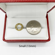 Small 10k gold round stud earring next to a U.S. quarter for size comparison.