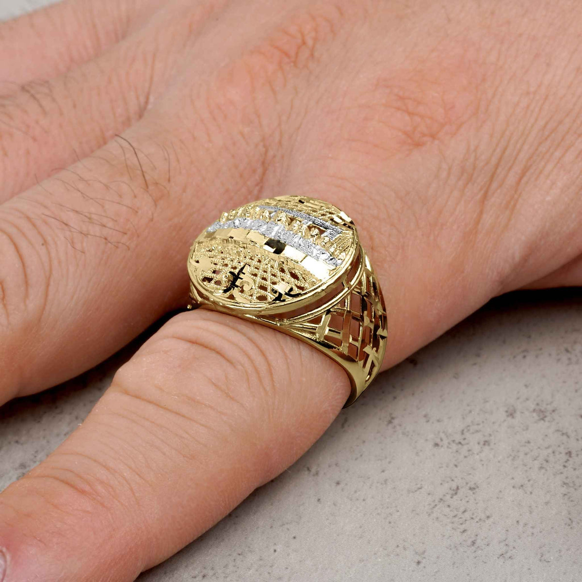 A two-tone 10k gold round Last Supper signet ring worn on a pinky finger.