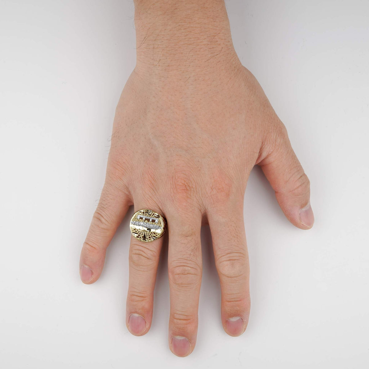 Hand wearing the 10k two-tone gold round Last Supper ring on a white background.