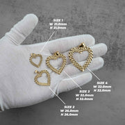 Multiple 10k yellow gold Rolex-style heart pendants laid out on a display surface.