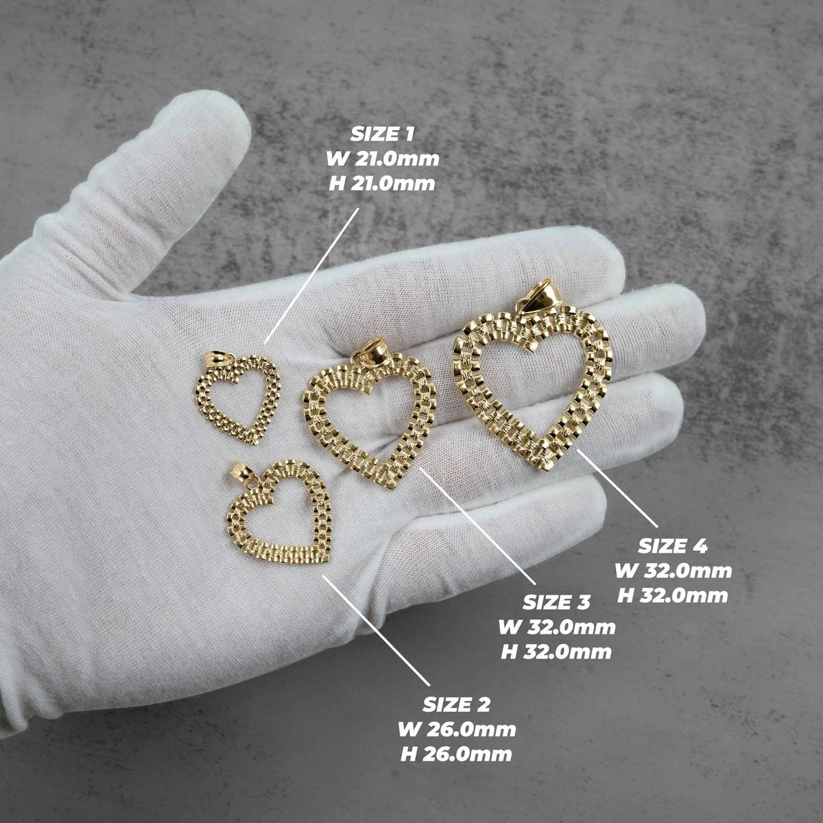 Multiple 10k yellow gold Rolex-style heart pendants laid out on a display surface.