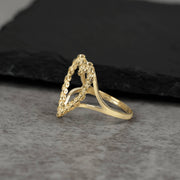 Side view of a 10k yellow gold ring showcasing a cut-out heart with link textures.