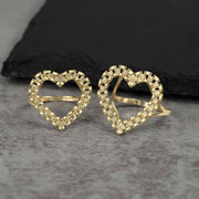 A pair of vintage-inspired 10k yellow gold heart rings featuring intricate link detailing.