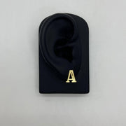 Single gold diamond-cut initial letter 'A' stud earring displayed on a black ear model.