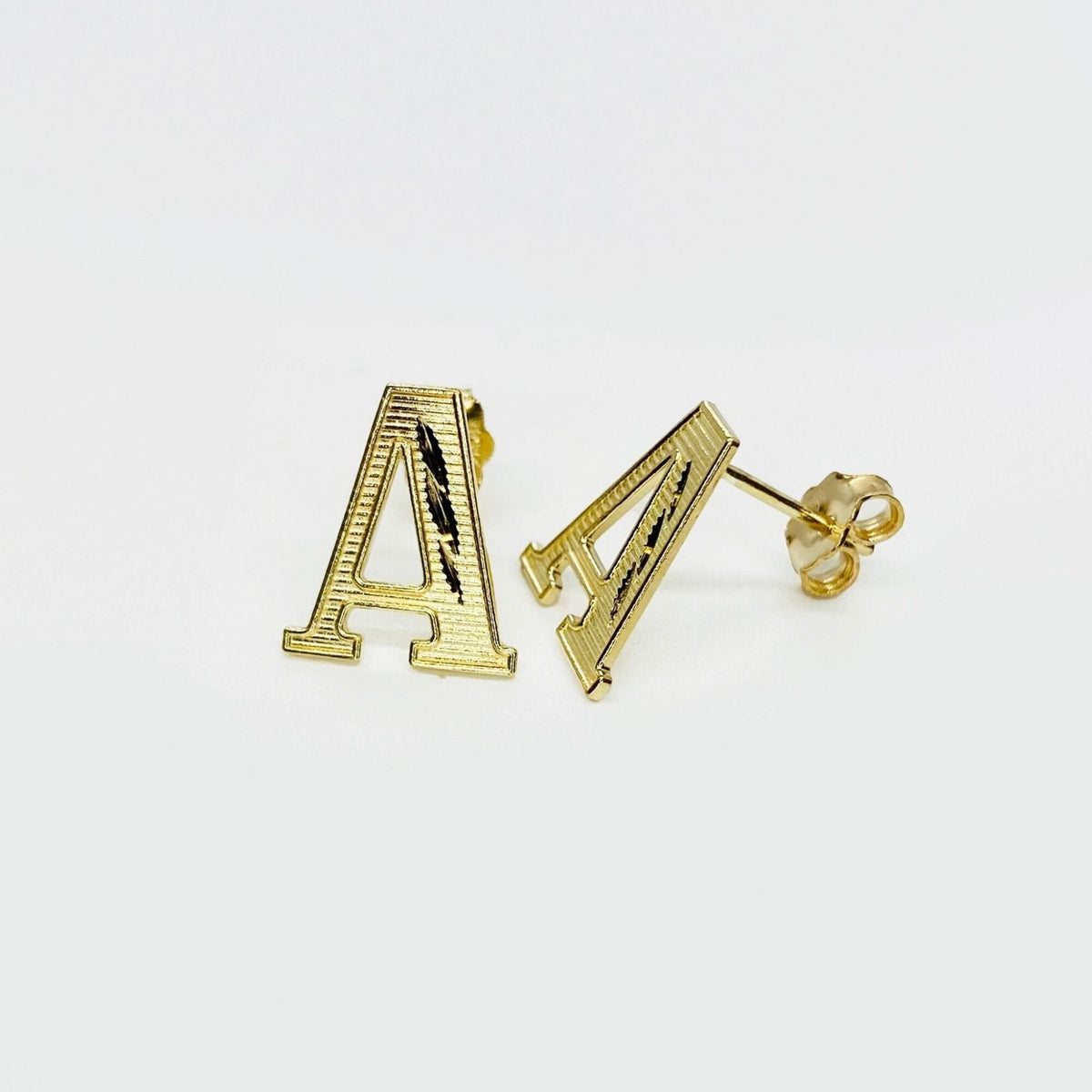 Pair of gold diamond-cut initial letter 'A' stud earrings on a white background.