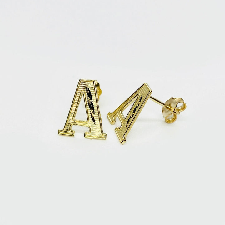 Pair of gold diamond-cut initial letter 'A' stud earrings on a white background.