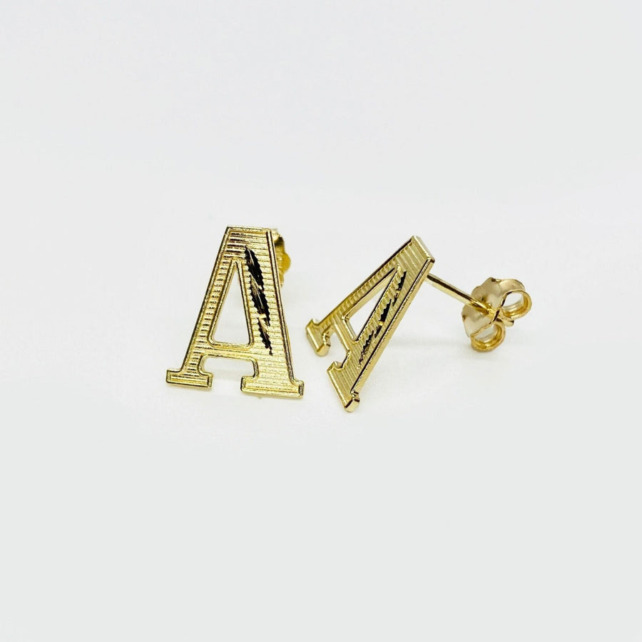 Pair of gold diamond-cut initial letter 'A' stud earrings on a white background.