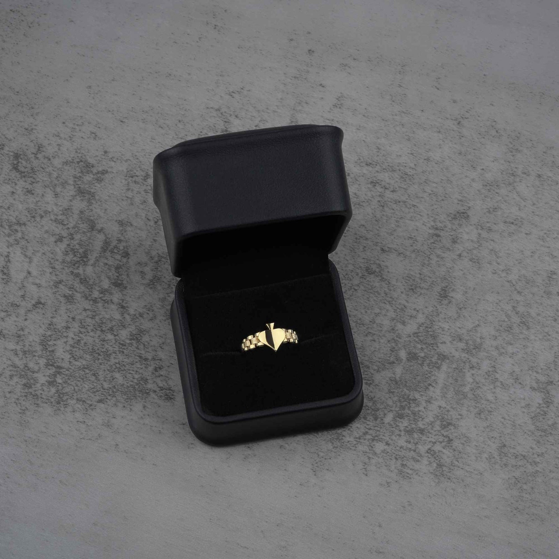 sleek classic 10K gold spade ring on a black jewelry box front view