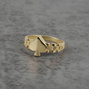 10k Gold ring with a spade design on a gray surface