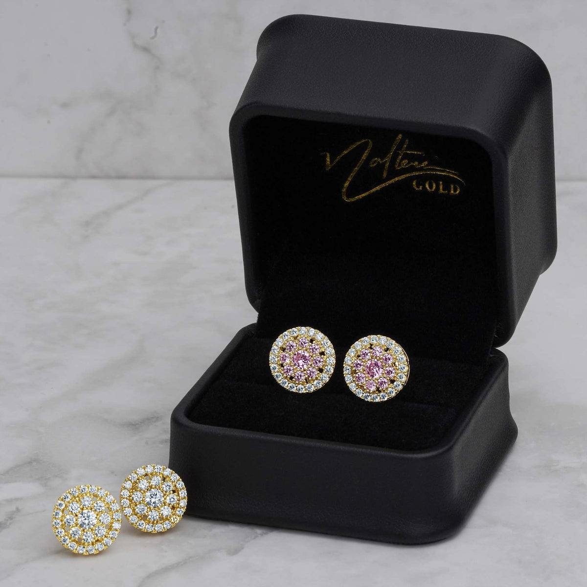 Pink and white CZ round gold stud earrings inside a black jewelry gift box.